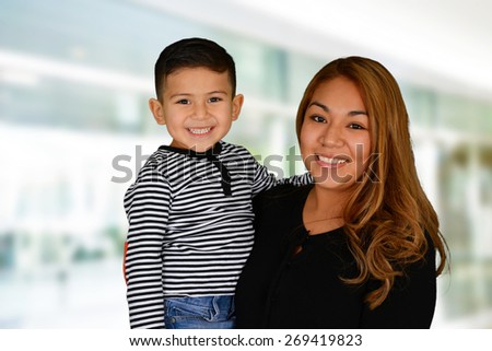 Happy young mother and son hugging and smiling