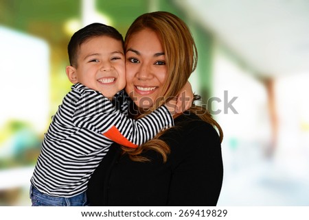 Happy young mother and son hugging and smiling