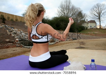 Young woman doing yoga outside at a spa