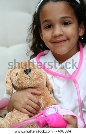 Young girl plays doctor or nurse with stuffed animal