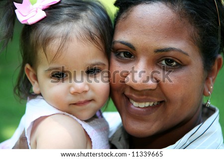 Interracial mother and daughter playing in their yard