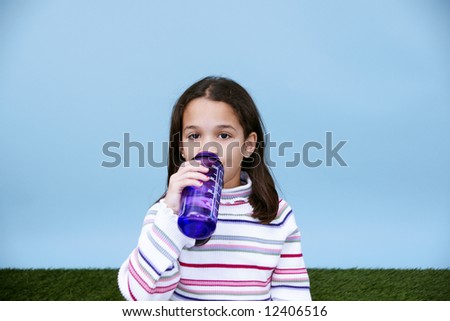 Young girl drinking from a bottle of water