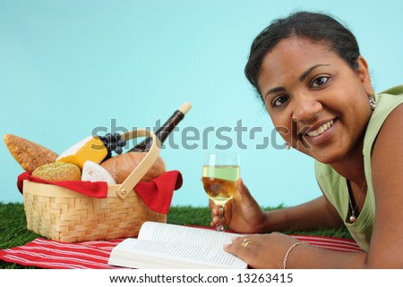 Picnic Basket filled with food while woman reads book
