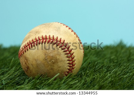 Old Baseball Sitting On A Green Field