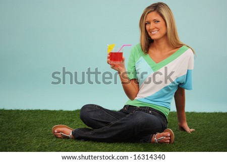 Woman Sitting Outside In The Grass With A Drink