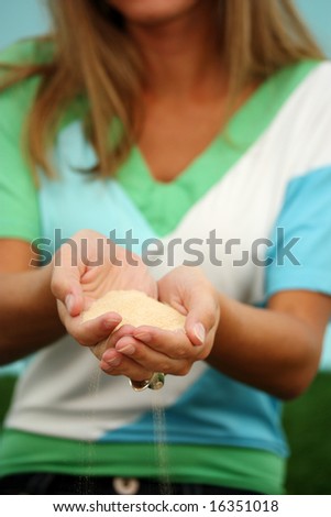 Woman Holding A Pile Of Sand In Her Hands
