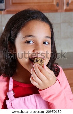 Girl eating cookie dough in the kitchen