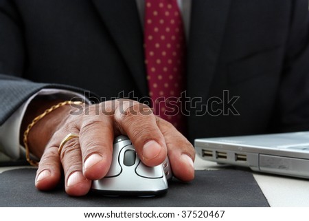 Minority businessman on his laptop computer with mouse
