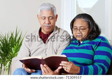 Couple reading the bible in their home