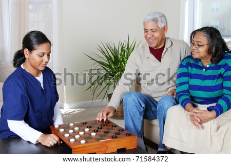 Home health care worker and an elderly couple playing game