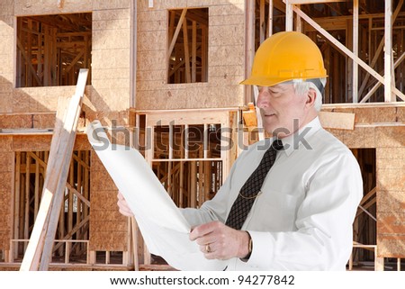 Senior construction worker looking at plans on job