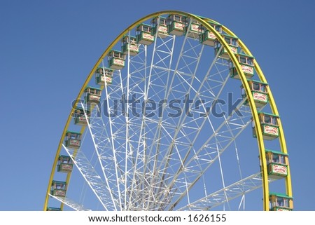 Top half of an observation wheel spinning on a carnival area