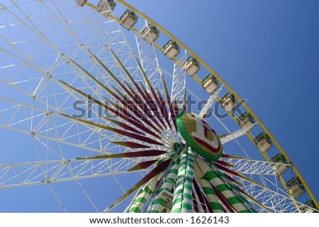 Perspective view of an observation wheel spinning in clear blue summer sky