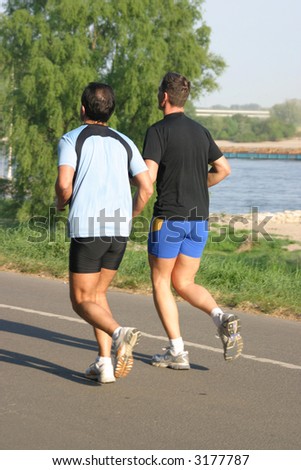 Two male jogger doing their training after work in the late afternoon sun at the riverside