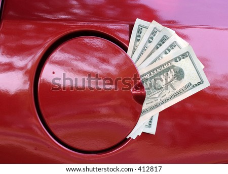 Twenty dollar bills sticking out of gas cap opening representing and illustrating the high cost of gasoline.