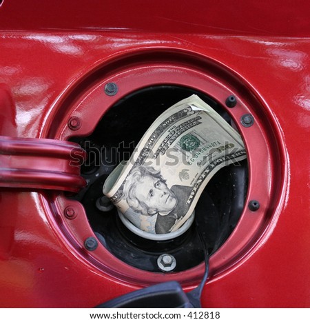Twenty dollar bills sticking out of gas tank opening representing and illustrating the high cost of gasoline.