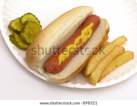 Hot dog with mustard fries and pickles on paper plate
