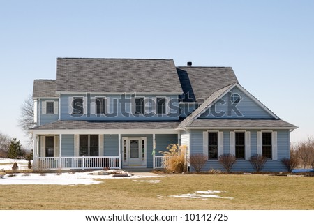 A nice winter photo of a house with blue siding