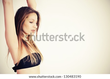 Portrait of sexy caucasian young woman relaxing with beautiful healthy body. Hands up. Warm colors.