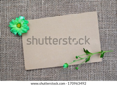 Brown background with flowers and copy space. Blank page for design with sack texture. Gift card. Empty vintage postcard on sacking cloth.