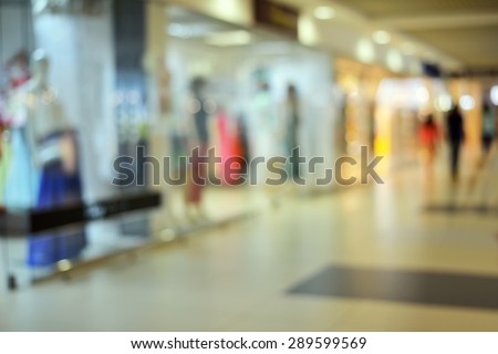 Shoppers at shopping center, motion blur. Blurred background of shopping center