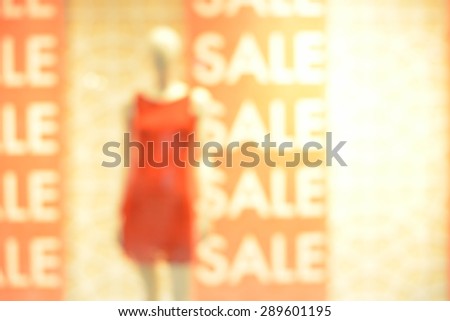 window display with text SALE in a shop. Blurred background.