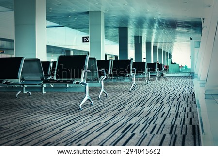 Bench in the airport hall. Photo with color filters and film grain effect. Airport chairs.