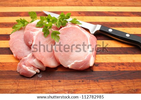 Pork Loin steaks with knife on the chopping board