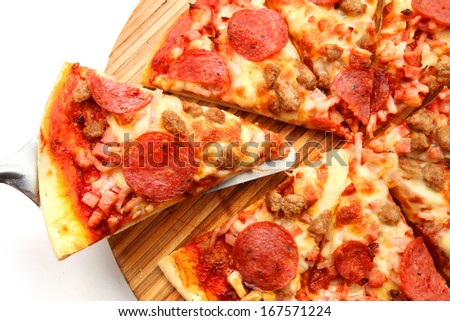 lifted slice salami pizza on a wooden chopping board