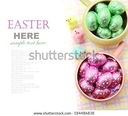 Easter chocolate eggs in the bowl with little toy chicks isolated on white
