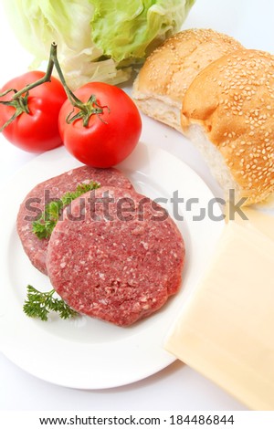 Fresh burger ingredients, patty with lettuce,burger,slice cheese and tomato isolated on white