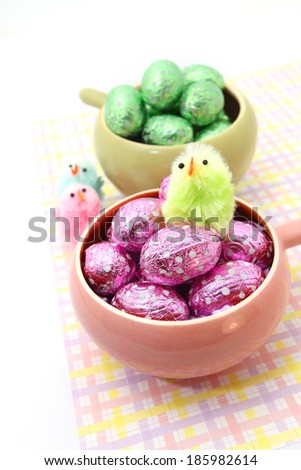Easter chocolate eggs in the bowl with little Easter chicken