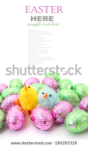 Colorful Easter chocolate eggs with little Easter chicken isolated on white