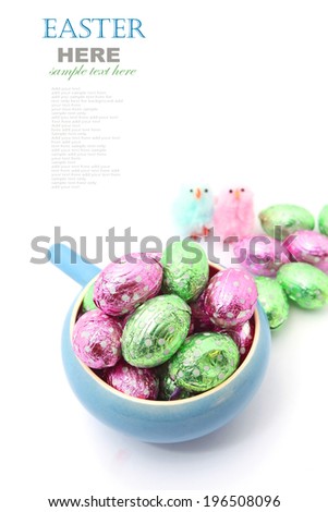 Easter chocolate eggs in the bowl with little Easter chicken isolated on white