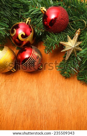Background with copy space: Christmas decoration (branch of spruce tree, bubbles and star) on the wooden background