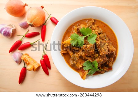 Beef Curry in a bowl on the wooden table with ingredients