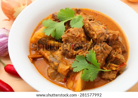 Beef Curry in a bowl on the wooden table with ingredients