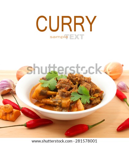 Beef Curry in a bowl on the wooden table with ingredients isolated on white