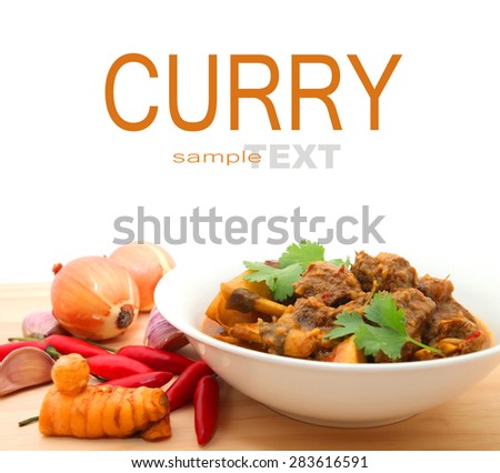 Beef Curry in a bowl on the wooden table with ingredients isolated on white