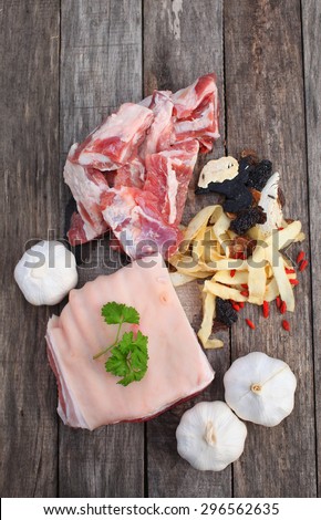 Assortment Of Chinese Herb with raw pork ribs and pork belly on the wooden table