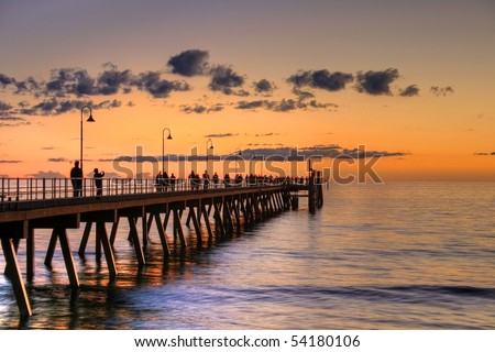 Jetty with people silhouette during sunset