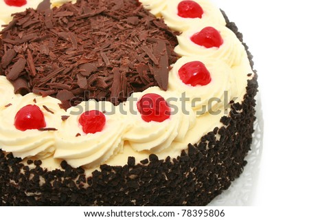 Black forest cake, topped with whipped cream and cherry isolated on white