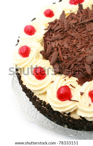 Black forest cake, topped with whipped cream and cherry isolated on white