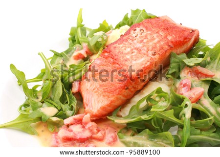 Fried Salmon Steak with baby rocket salad isolated on white