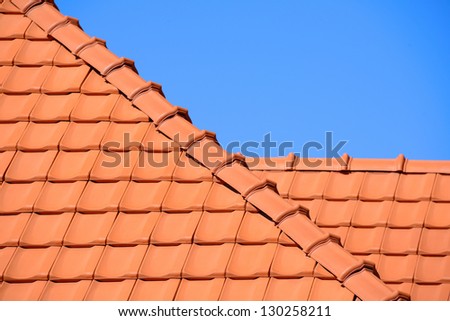 Red tiles roof background on blue sky background / Rooftop