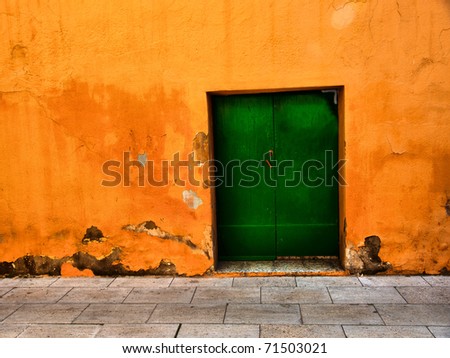 Aged metal door on orange wall / Door / Background / Wall / Barcelona, Spain, Europe