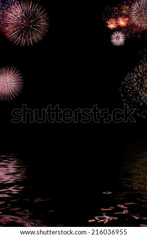 Border (or frame) composed of colorful firework flashes isolated on black background along with their reflections in wavy water surface with empty copyspace in  middle to insert some text or images.