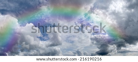 A sky atmosphere nature scene (cloudscape) with cumulus cloud clouds , and rainbow. Can be used as a background or wallpaper.