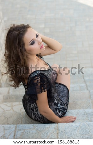 young attractive happy female sits on stairs, outdoor shoot
