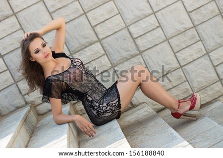 young attractive happy female sits on stairs, outdoor shoot